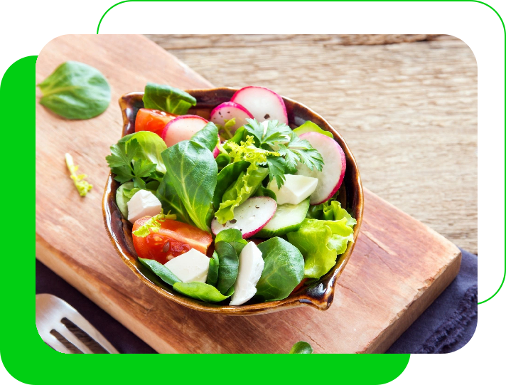 A bowl of salad on top of a wooden board.