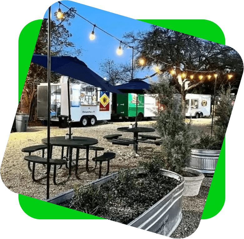 A group of tables and chairs in the middle of an outdoor area.